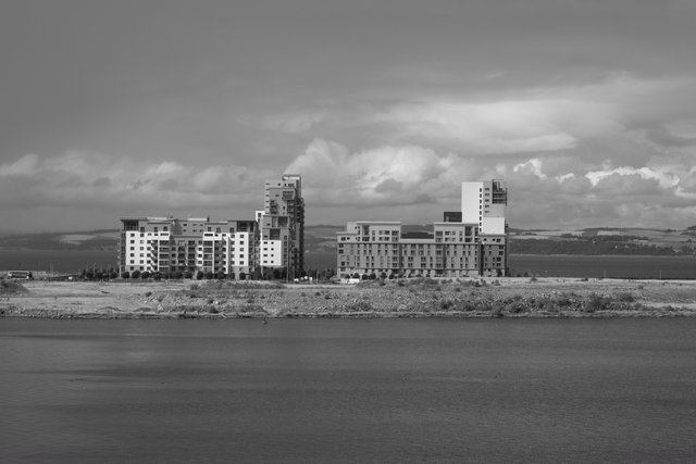 Apartment blocks on the far shore of the Firth of Forth, black and white