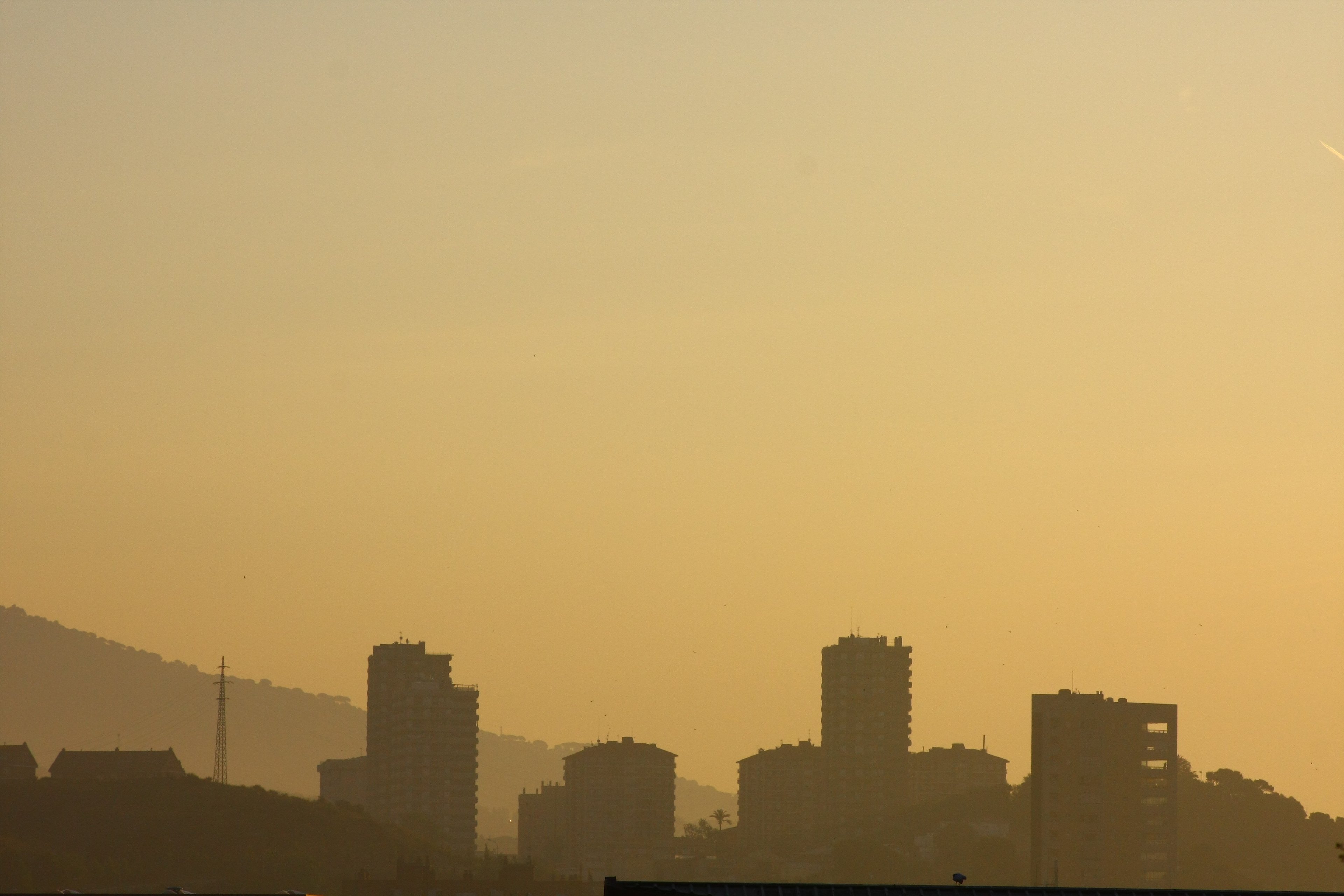 City towers silhouetted in amber haze at dusk