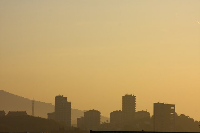 City towers silhouetted in amber haze at dusk